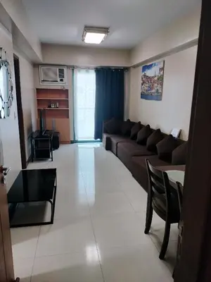 a living room with a couch and a table at 1 Bedroom Near Airport Pasay City in Manila