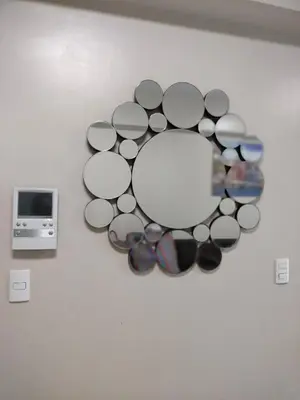 a circle of glasses on a wall with a mirror at 1 Bedroom Near Airport Pasay City in Manila