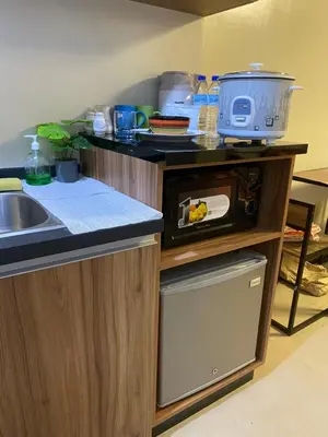 a kitchen with a sink and a microwave on a counter at Cozy studio unit 10mins from Airport 20mins from US Embassy across SM Sucat in Manila