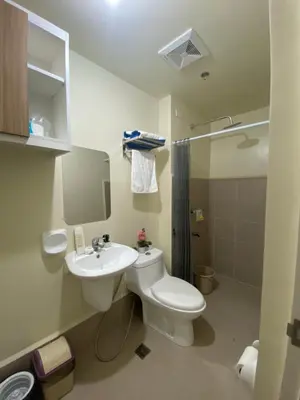 a bathroom with a toilet and a sink and a shower at Cozy studio unit 10mins from Airport 20mins from US Embassy across SM Sucat in Manila