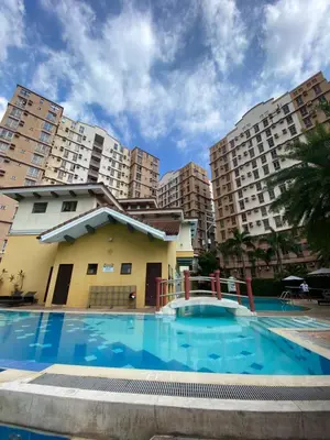 a swimming pool in front of some apartment buildings at Cozy studio unit 10mins from Airport 20mins from US Embassy across SM Sucat in Manila