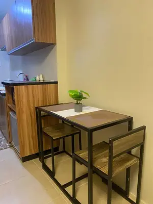 a table and chairs in a kitchen with a plant on it at Cozy studio unit 10mins from Airport 20mins from US Embassy across SM Sucat in Manila