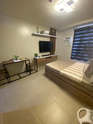 a bedroom with a bed and a television in it at Cozy studio unit 10mins from Airport 20mins from US Embassy across SM Sucat in Manila