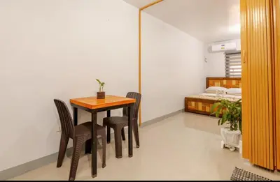 a dining room with a table and chairs and a bed at Rosie's Staycation in Trece Martires, Cavite in Quintana