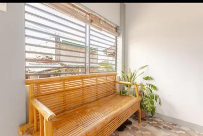 a wooden bench sitting in front of a window at Rosie's Staycation in Trece Martires, Cavite in Quintana