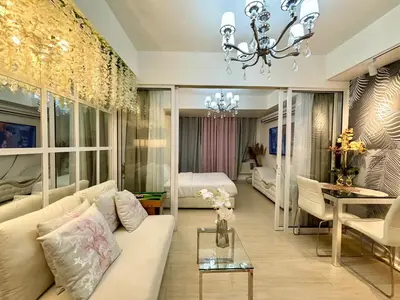 a living room with a couch and a bedroom at Home Sweet Home - Azure in Manila