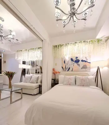 a bedroom with a white bed and a chandelier at Home Sweet Home - Azure in Manila