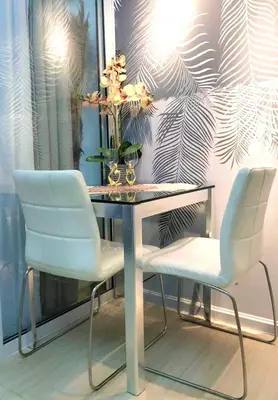 a table with two chairs and a vase with flowers on it at Home Sweet Home - Azure in Manila