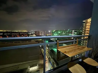 a bench on the balcony of a building at night at Home Sweet Home - Azure in Manila