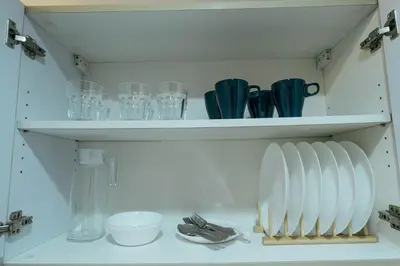a shelf with plates and glasses on it at Modern Living 5 with Fast Wifi and Netflix in Manila