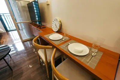 a dining room table with two plates and a clock at Modern Living 5 with Fast Wifi and Netflix in Manila