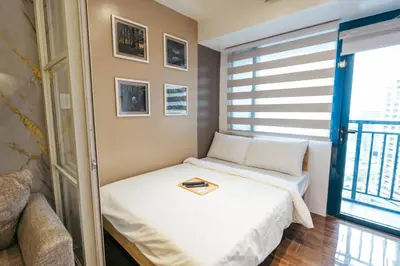 a small bedroom with a bed and a window at Modern Living 5 with Fast Wifi and Netflix in Manila