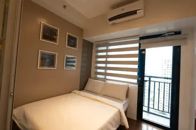 a small bedroom with a bed and a window at Modern Living 5 with Fast Wifi and Netflix in Manila