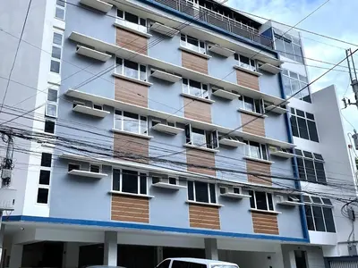 a tall white building with lots of windows at The Circuit Manor Hotel near Ayala Malls Circuit in Manila