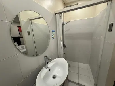 a bathroom with a sink and a mirror at The Circuit Manor Hotel near Ayala Malls Circuit in Manila