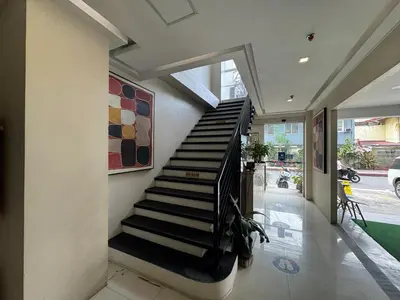 a hallway with a staircase in a house at The Circuit Manor Hotel near Ayala Malls Circuit in Manila