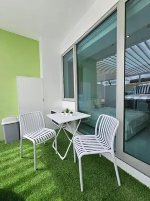 two chairs and a table on a balcony with grass at Rio Primea in Manila