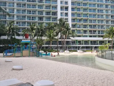 a beach in front of a large building at Rio Primea in Manila
