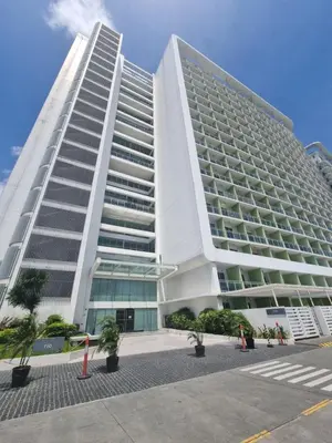 a large white building with trees in front of it at Rio Primea in Manila