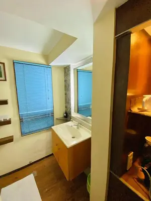 a bathroom with a sink and two windows in it at Casa Verde Hotel & Events Center in Imus