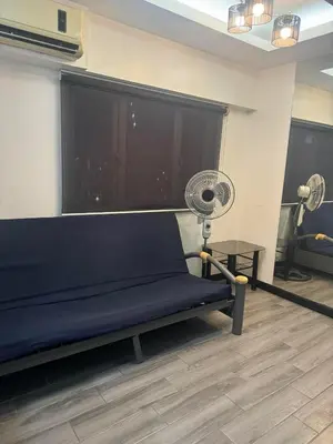 a room with a blue bench and a fan at Ladybyugs Condotel Rental in Manila