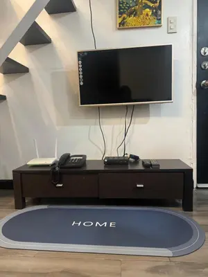 a tv sitting on top of a stand with a table at Ladybyugs Condotel Rental in Manila