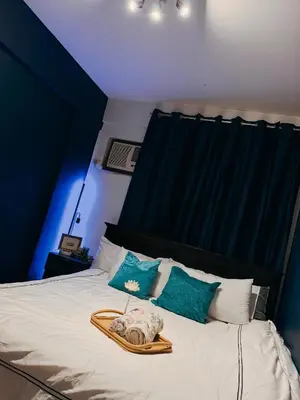 a bed with a tray with a towel on it at Moody Space near NAIA TERMINALS in Manila