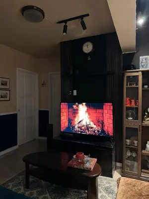 a living room with a tv with a fire on it at Moody Space near NAIA TERMINALS in Manila