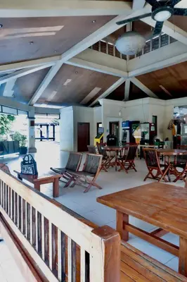 a patio with wooden tables and chairs in a building at Moody Space near NAIA TERMINALS in Manila