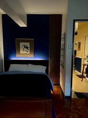 a bedroom with a bed with a blue wall at Moody Space near NAIA TERMINALS in Manila