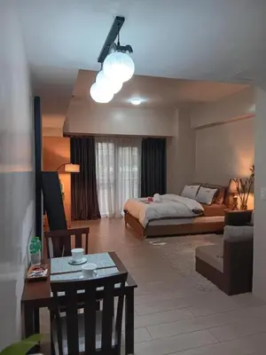 a living room with a bed and a table at M&N Condotel in Manila
