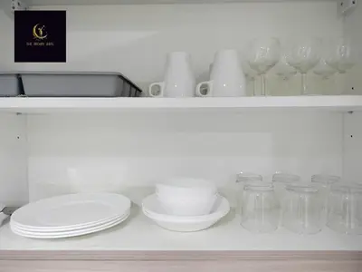 a white shelf with plates and glasses on it at Newly opened near MOA & Airport with PS4 and karaoke in Manila