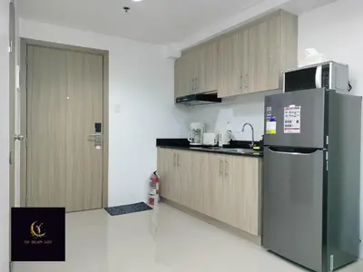 a kitchen with a stainless steel refrigerator and wooden cabinets at Newly opened near MOA & Airport with PS4 and karaoke in Manila