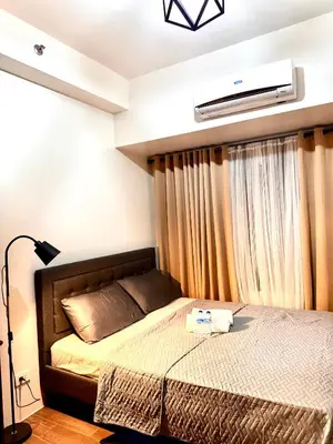 a bedroom with a bed and a air conditioner at Makati City Oasis The Air Residences #2148 in Manila