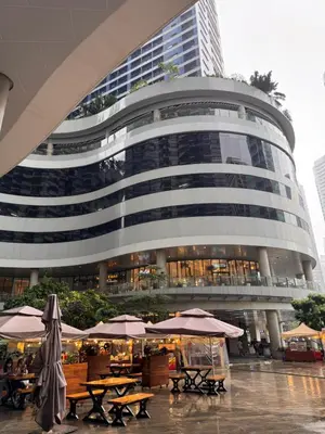 a building with tables and umbrellas in front of it at Makati City Oasis The Air Residences #2148 in Manila
