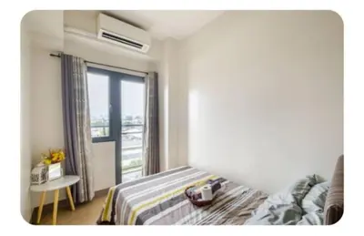 a bedroom with a bed and a large window at Benjamin's crib staycation in Manila