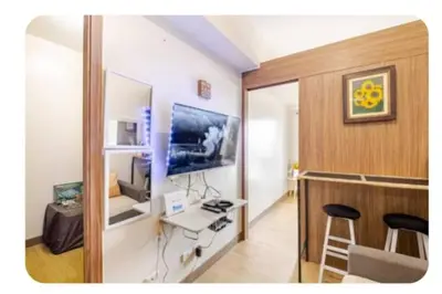 a room with a desk and a tv in a room at Benjamin's crib staycation in Manila