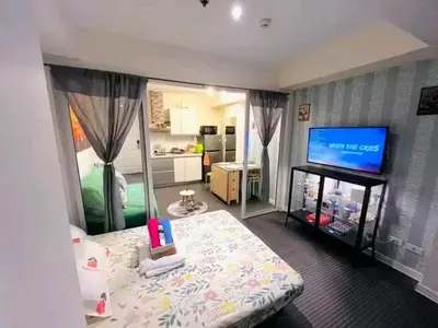 a bedroom with a bed and a flat screen tv at Azure Urban Resort Staycation By Yana in Manila