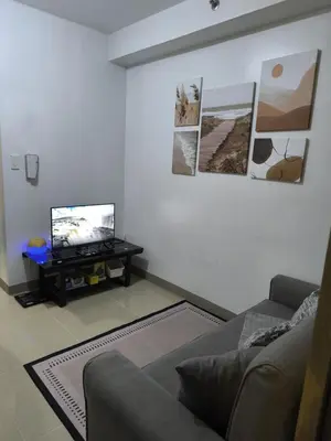 a living room with a couch and a tv at Shore 2 Residences - La Casa in Manila