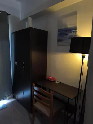 a desk with a lamp and a cabinet in a room at Shore 2 Residences - La Casa in Manila