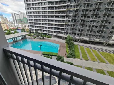 a balcony of a building with a swimming pool at Sleek 1 BR APT at FAME Residences with Balcony in Manila