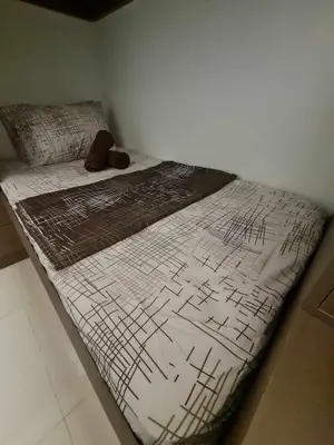 a bed in a corner of a room at Sleek 1 BR APT at FAME Residences with Balcony in Manila