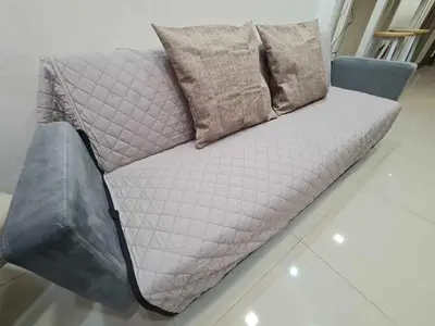 a grey couch with pillows on a floor at Sleek 1 BR APT at FAME Residences with Balcony in Manila