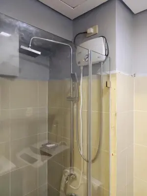 a shower with a glass door in a bathroom at ck staycation coast residence in Manila