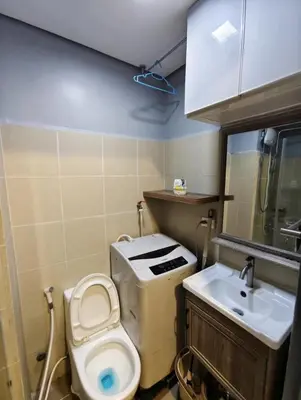 a small bathroom with a toilet and a sink at ck staycation coast residence in Manila