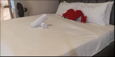 a white bed with a red stuffed animal on it at JRM Staycation Naia T3 in Manila