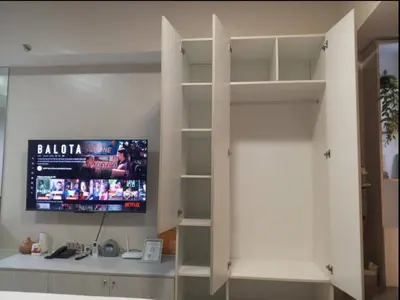 a room with a tv on a wall with shelves at JRM Staycation Naia T3 in Manila
