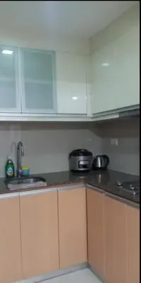 a kitchen with white cabinets and a sink at JRM Staycation Naia T3 in Manila