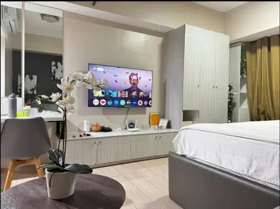 a bedroom with a bed and a flat screen tv at JRM Staycation Naia T3 in Manila