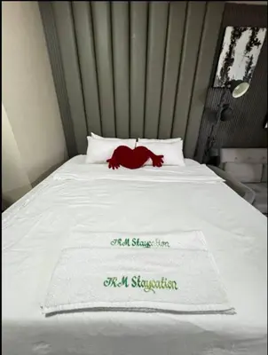 a white bed with a red blanket on it at JRM Staycation Naia T3 in Manila